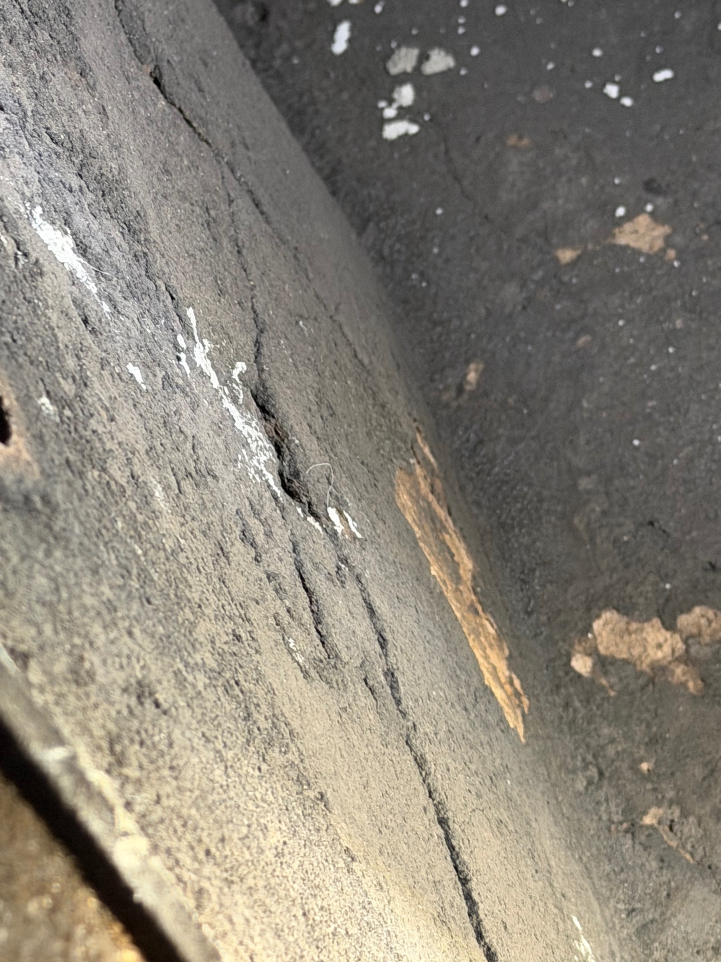 Sooty smoke chamber with open cracks and crumbling parging